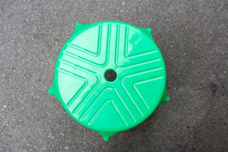 Rounded shape green plastic chair on cement floor. Top view.の写真素材
