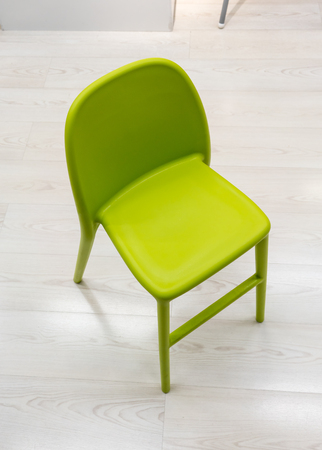 Green plastic modern design chair on wood floor.の写真素材