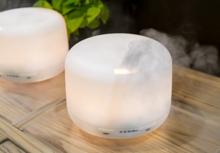 Electric aroma oil diffuser on wooden floorの写真素材