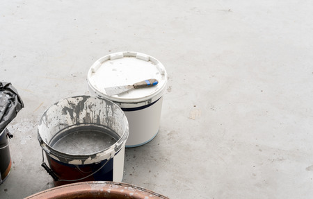 Dirty or used color buckets and construction equipment on polish cement floor with copy space.