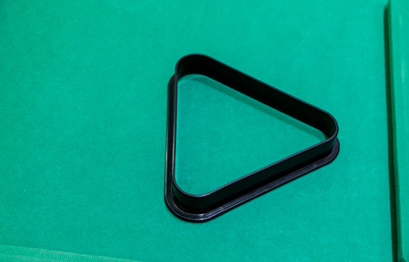 a black plastic pool and snooker triangle on green tableの写真素材