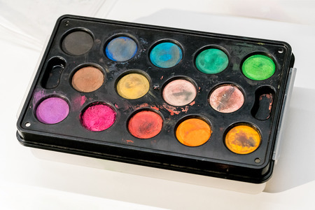 Watercolor paints box isolated on white background. Used paint palette.