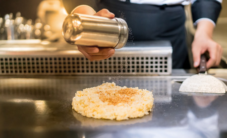 Hand of Chef cooking garlic fried rice on hot pan in front of customers. Japanese Tepanyaki Steakの写真素材