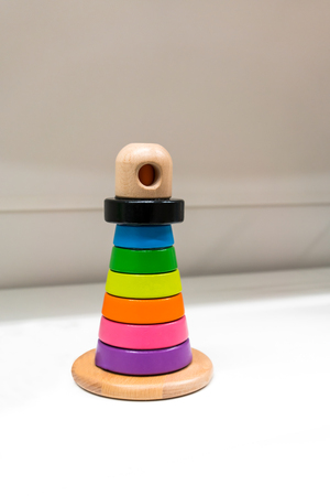 Colorful wooden toy stand alone on white shelfの写真素材