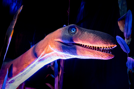 Dinosaur model in the pink, purple and blue environment. Selective focusのeditorial素材