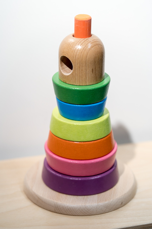 Colorful wooden toy stand alone on wooden shelfの写真素材