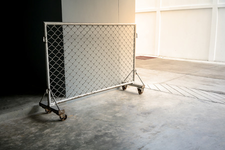Moveable wire fence barrier with metal wheels on concrete floorの写真素材