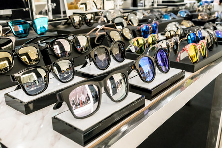 Various of sun glasses in the shop display shelves. Selective focus