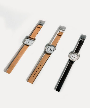 Classic minimal leather wrist watches on white modern display.