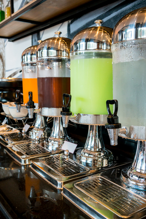 Variety of juice in beverage dispenser for breakfast. Selective focus.の写真素材