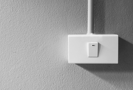 Closeup of lighting electrical switch against concrete background