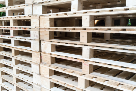 Stack of wooden pallets in factory warehouse for industrial transportation by trucks