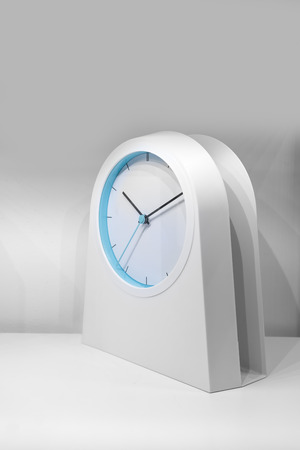Modern white and blue clock on white table for decorationの写真素材
