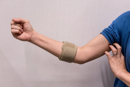 Asian woman wearing elbow brace to reduce painの写真素材