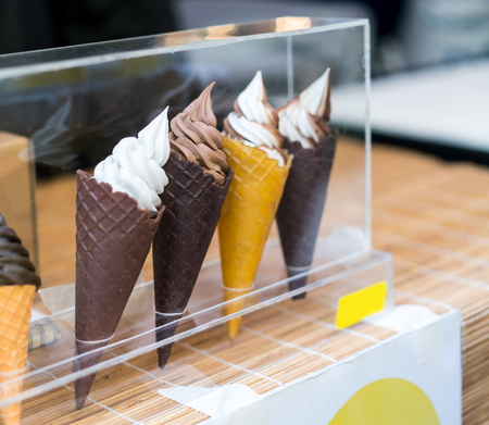 Variety of ice cream scoops in cones with chocolate, vanilla and coffee. Artificial ice creamの写真素材