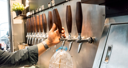 taps for beer bottling and other drinks on silver metal backgroundの写真素材