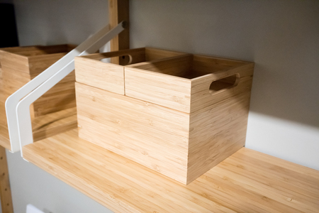 Empty squared wooden container for organizer on modern floating shelf. Idea for home decoration.の写真素材