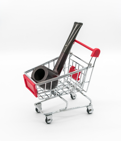 Vintage dark brown pipe in red shopping cart isolated on white background