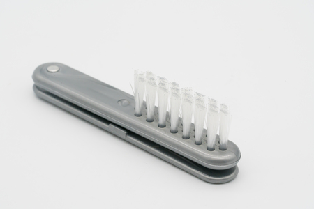 Small foldable plastic brush in grey color isolated on white background