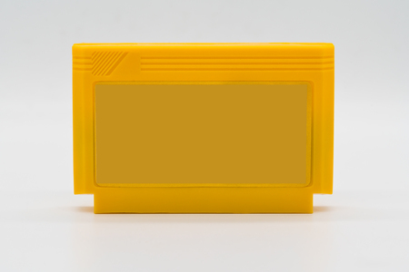 TV game cartridge in plastic yellow case from 90s isolated on white background