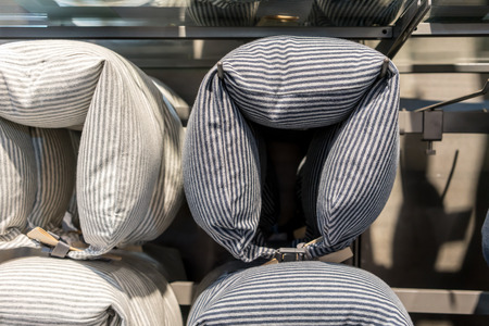 Neck pillows hanging on metal bar in store display for saleの写真素材