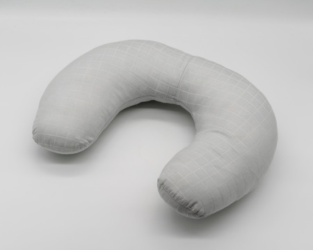 Neck pillows with light grey fabric and white table pattern isolated on white backgroundの写真素材