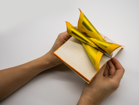 Hand holding Joss Paper Chinese Tradition for Passed Away Ancestor's spirits, Isolated on white...