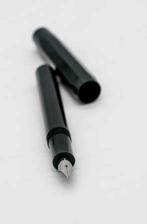 Black fountain pen with silver nib isolated on white background. Selective focus at the center of the nib with the shallow depth of field.の写真素材