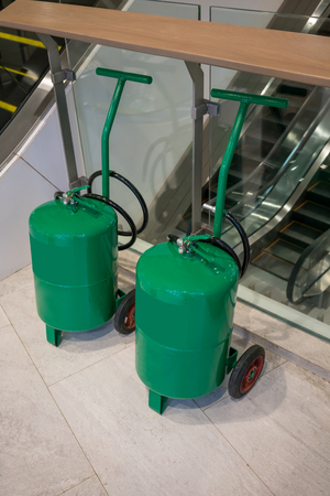 Fire protection equipment, Fire extinguisher on trolley located near escalatorの写真素材