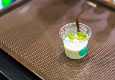 Smoothie beverage sample for refreshing concept in transparent tasting cup on brown tray. Marketing promotion for new launched flavor.の写真素材