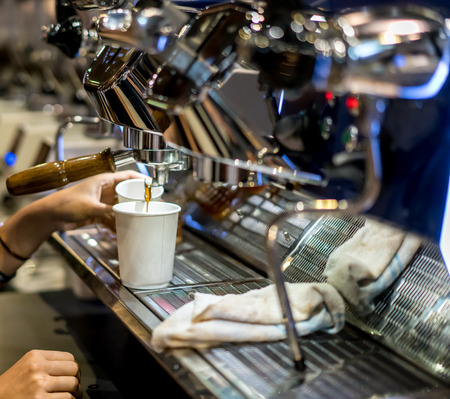 Barista hand setting up the coffee machine in vintage design for perfect espresso shot flow.の写真素材