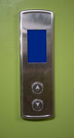 Silver elevator buttons panel with LED digital screen against green backgroundの写真素材