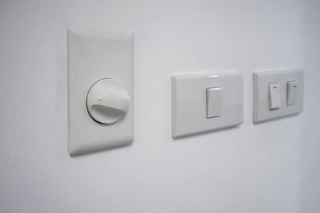 An electric cycle fan dimmer switch against white wall backgroundの写真素材