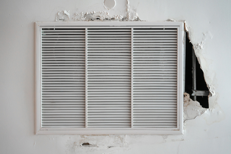Damaged air ventilator ,metal slat frame on white ceiling