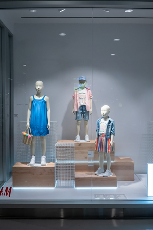 H&M Kid shop at Emquatier, Bangkok, Thailand, Sep 26, 2017 : Fashionable brand window display. Casual Kid clothings and accessories showcase in front of the store.  Selective focus.のeditorial素材