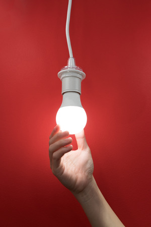 Woman hand holding light bulb, concept of new ideas with innovation and creativity.の写真素材