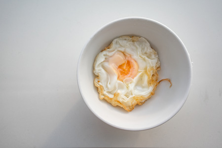 Closed up beautiful fried egg in white bowl isolated on white background. Safety food served for patient in the hospital.の写真素材