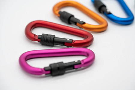 Colorful matte metal aluminum snap hook isolated on white background. Safety lock carabiner for rope climbingの写真素材