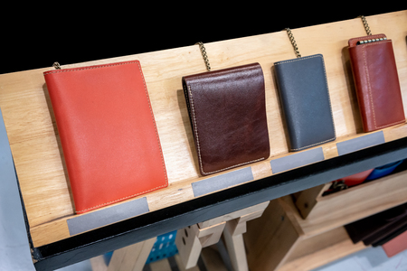 Colorful leather wallet display on wooden shelve in store for sale.の写真素材