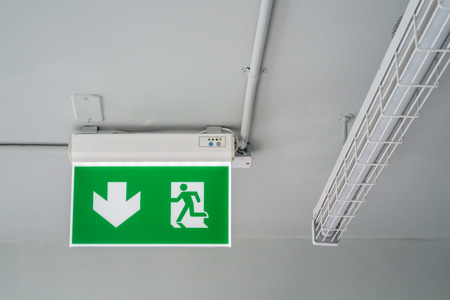 Green emergency exit sign. Direction to the escape way.の写真素材