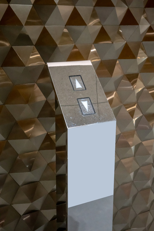 Luxury elevator buttons on chrome stand againts hexagon texture pattern background