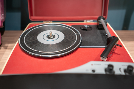 Red and black modern vinyl player on wooden table. Retro vintage style.の写真素材
