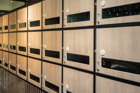 Wall of wooden postal mailboxes and lockers Communication throwback concept. Empty post box row for...