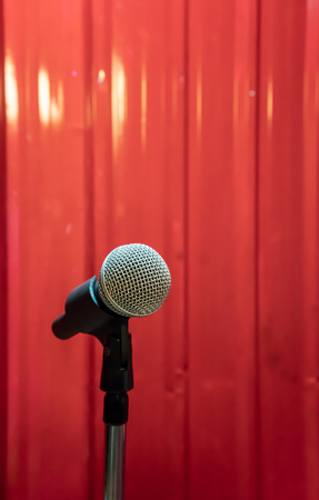 Close up of microphone against red metal sheet wall backgroundの写真素材