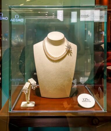 Mikimoto shop at Siam Paragon, Bangkok, Thailand, May 9, 2018 : 125th anniverary luxury pearl necklaces and earrings set in glass box for visual mechandising.のeditorial素材