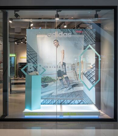 Adidas shop at Central Westgate Bangkok, Thailand, May 10, 2018 : Fashionable sportswear brand visual merchandising. Modern white design window display.のeditorial素材