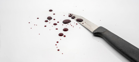 Closed up bloody kitchen knife with blood spatter and droplet on white background for Haloween concept.の写真素材