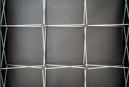 Light steel truss girder element against black background. Backdrop structure.