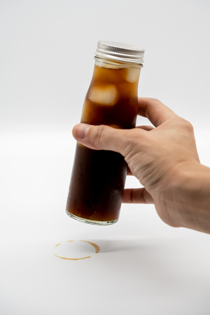 Woman's hand stamping a ring from coffee bottle for trademark isolated on white background.の写真素材