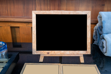 Mock up blank advertising black board with standing on black table in cafe and bar restaurant for display or montage of design space for text.の写真素材